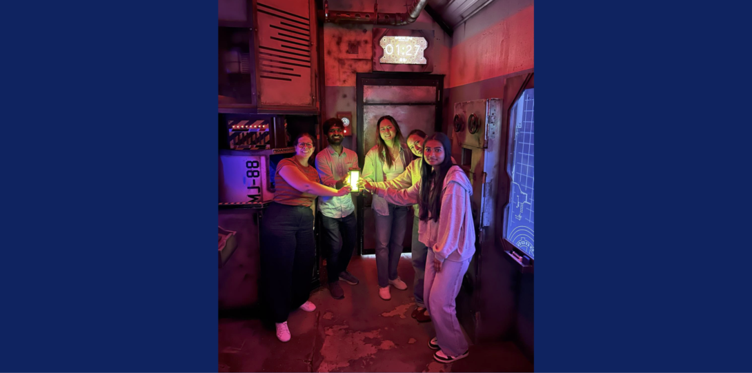 The 5 current members of the lab holding a glowing prop after successfully escaping from a nuclear bunker themed escape room.